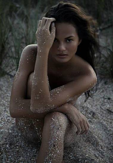 Chrissy Teigen covered with sand