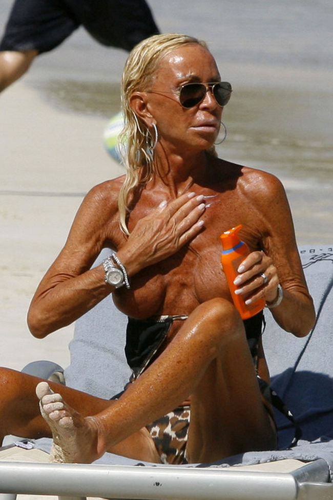 01-23-10 St Barts, France Donatella Versace applies tanning oil to her already very tanned chest while relaxing on the beach in St Barts. NON-EXCLUSIVE PIX by Flynet ©2010 818-307-4813 Nicolas
